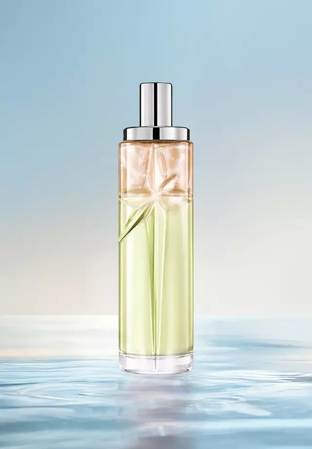 Recette de superposition Starlicious Creamy Delight : grand flacon présentant un dégradé de vert et d'ambre dans l'eau, sur un fond bleu clair. Parfum chaud, crémeux, légèrement sucré, aux notes de fruits à coque; 3 vaporisations de Pistachio Praline, 1 vaporisation de Pineapple Musk.