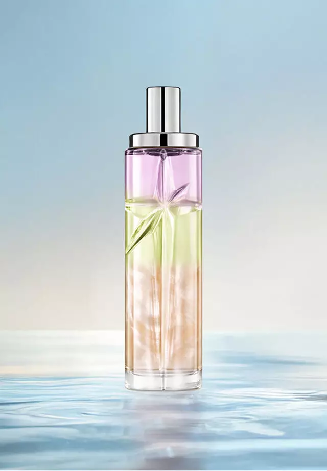 Recette de superposition de Starlicious Yummy Swirl : grand flacon présentant un dégradé violet, vert et orange sur l’eau, sur fond bleu doux. Parfum crémeux et tropical, aux notes subtiles de fruits à coque et rehaussé d’une touche de baies; 2 vaporisations de Pineapple Musk, 1 vaporisation de Pistachio Praline et 1 vaporisation de Berry Licorice.