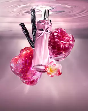 Une nature morte du Nouveau Starlicious Berry Licorice mettant en vedette le flacon de verre élancé entouré de ses ingrédients clés : une fraise rouge brillante, une framboise éclatante, une délicate fleur rose et des bâtons de réglisse noire torsadés, le tout sur un fond d’eau ondulante rose tendre.
